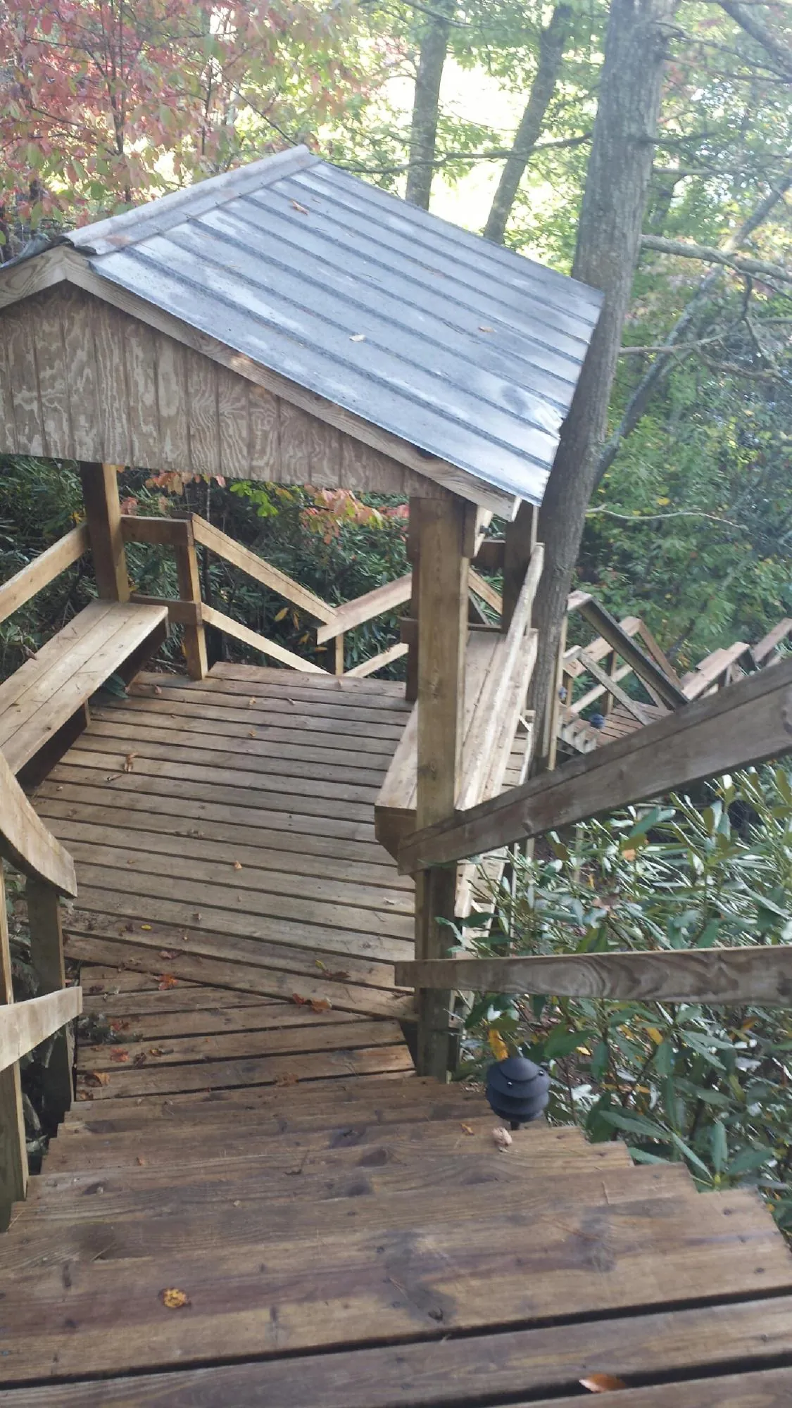 Metal roofed shelter over wooden steps on a wooded walkway — Skylight Repair & Installation work by our crew in Kingsbury