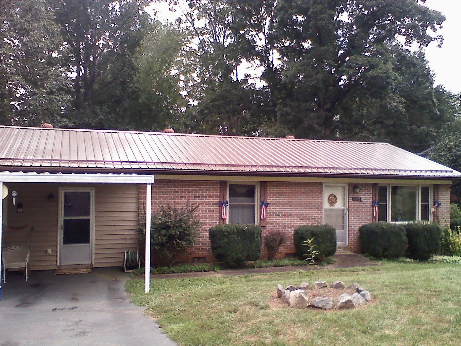 Bronze metal roof and carport on a brick ranch home — Roof Repair work by our crew in Kingsbury